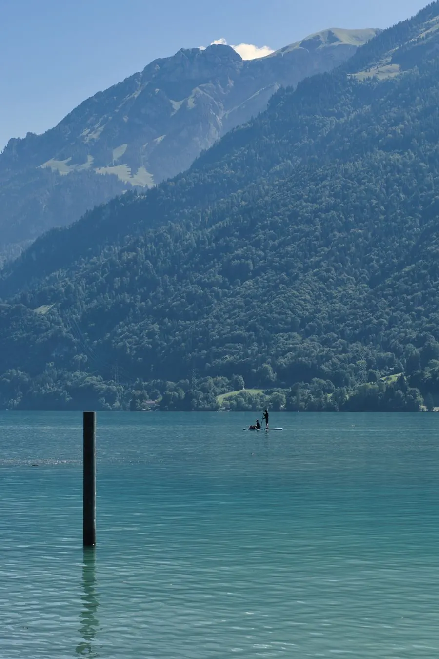 A paddleboarder on a calm mountain lake